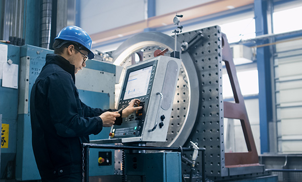 worker operating industrial machine with control panel in manufacturing facility using advanced technology for 8 precision tasks