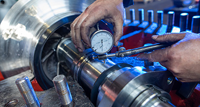 a worker using a dial gauge to measure the precision of a metal component during machining showing the importance of accuracy in engineering and manufacturing processes 2 tools and machines 2 precision measurements