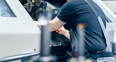 a worker operating a CNC machine in a manufacturing setting focusing on precision and efficiency in machining processes