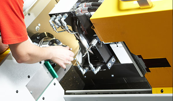 close-up of a precision machining process with a cutting tool on an aluminum component showcasing three distinct features of advanced manufacturing technology